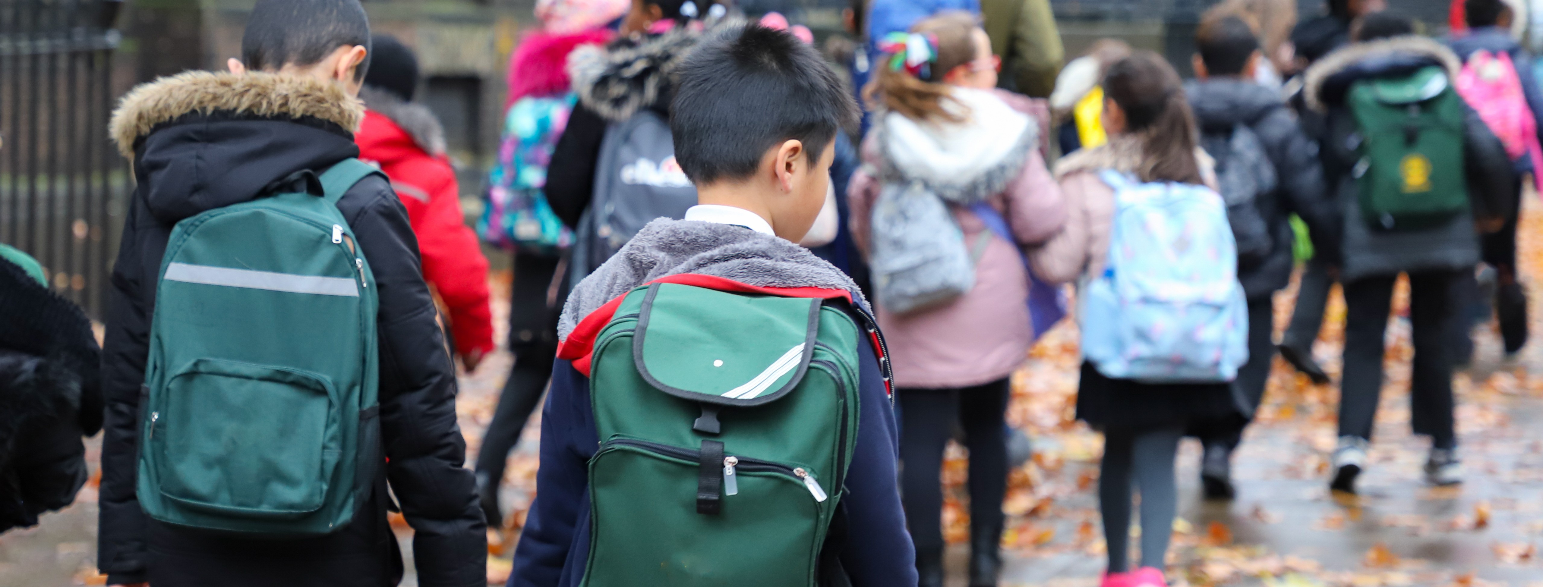 Children walking to school wearing back packs