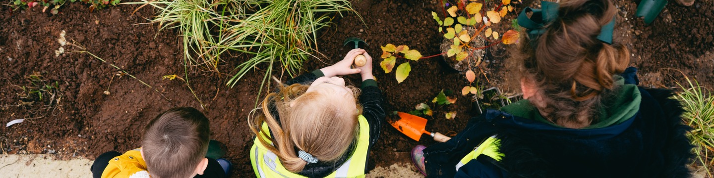 Children potting plants in Mixenden Rain Gardens
