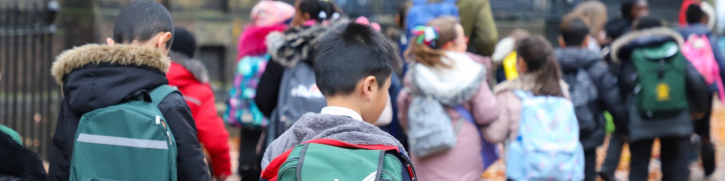 Young school children walking together along a street