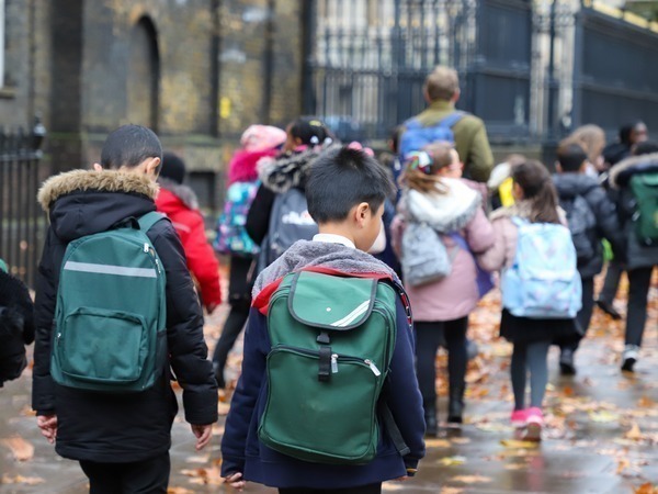 School children walking wearing backpacks
