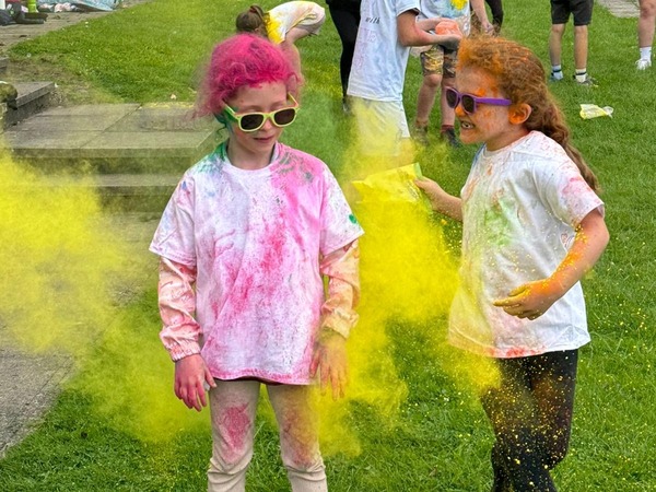Two children on a colour run in a park