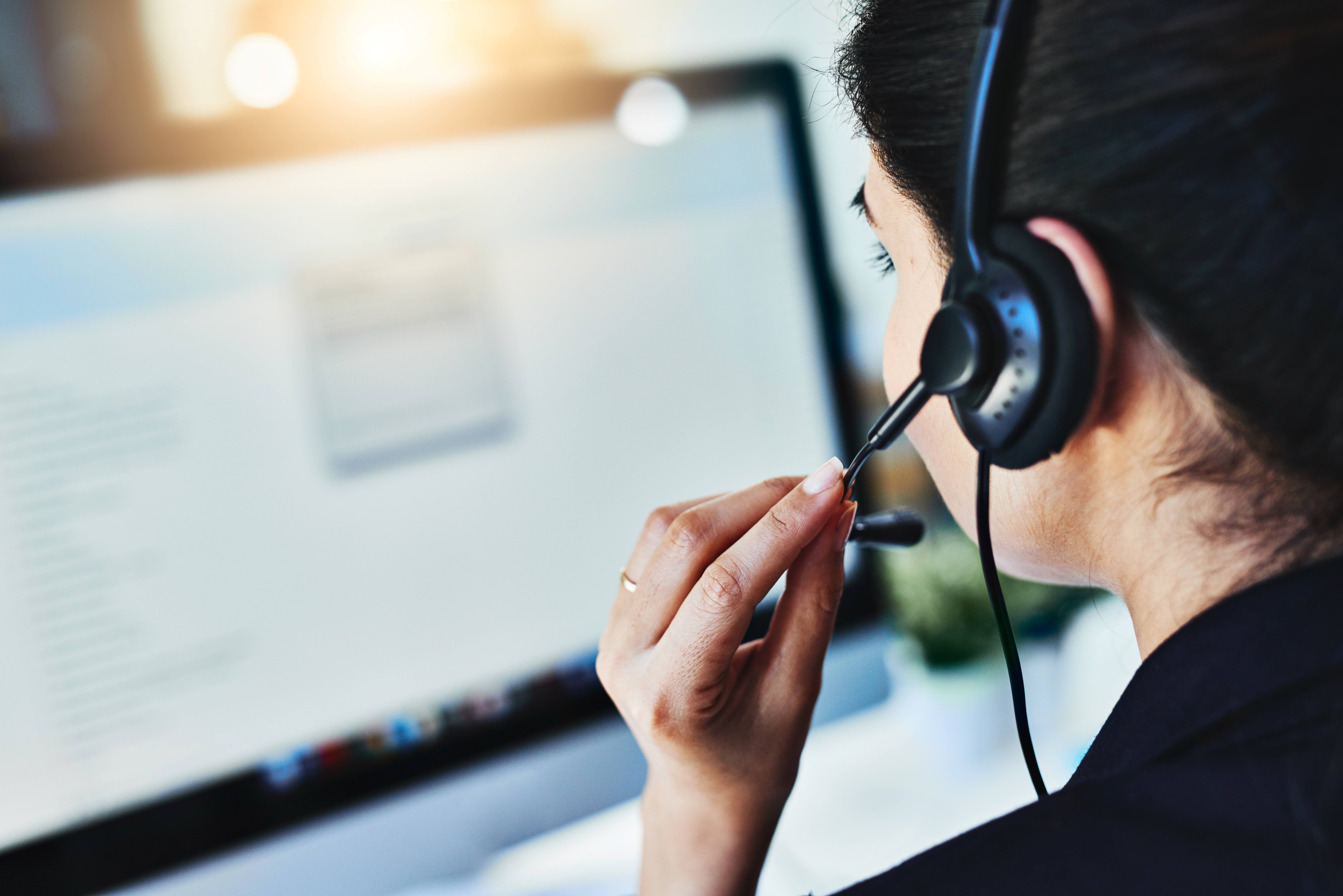 Woman at computer wearing audio headset